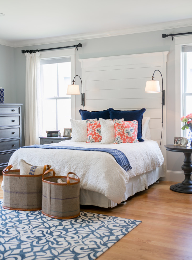 Inspiration for a mid-sized beach style master bedroom in Portland Maine with grey walls and light hardwood floors.