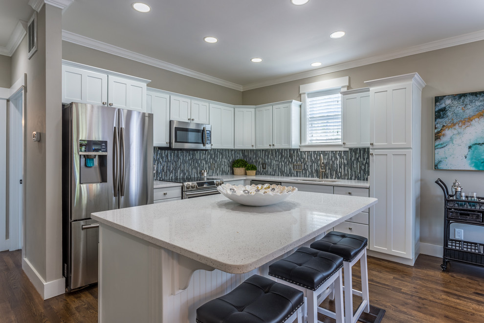 Example of a mid-sized transitional l-shaped dark wood floor and brown floor open concept kitchen design in Miami with an undermount sink, shaker cabinets, white cabinets, quartz countertops, multicolored backsplash, mosaic tile backsplash, stainless steel appliances and an island