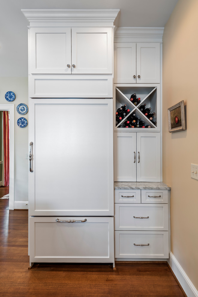 Large transitional l-shaped light wood floor eat-in kitchen photo with shaker cabinets, white cabinets, marble countertops, a farmhouse sink, green backsplash, ceramic backsplash, stainless steel appliances and an island