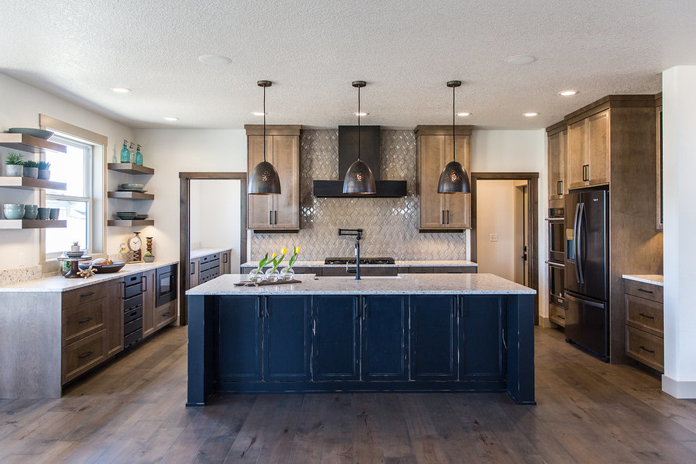 Example of a large transitional u-shaped medium tone wood floor and brown floor open concept kitchen design with a farmhouse sink, shaker cabinets, medium tone wood cabinets, quartz countertops, beige backsplash, ceramic backsplash, black appliances, an island and multicolored countertops