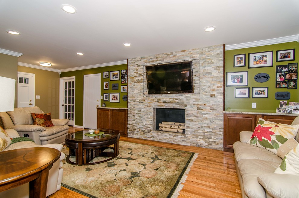 Inspiration for a mid-sized transitional enclosed family room in New York with green walls, light hardwood floors, a standard fireplace, a tile fireplace surround and a built-in media wall.