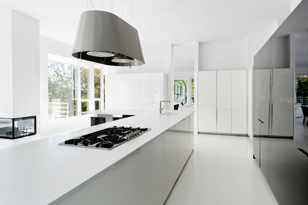 Photo of a contemporary galley kitchen in New York with flat-panel cabinets and with island.
