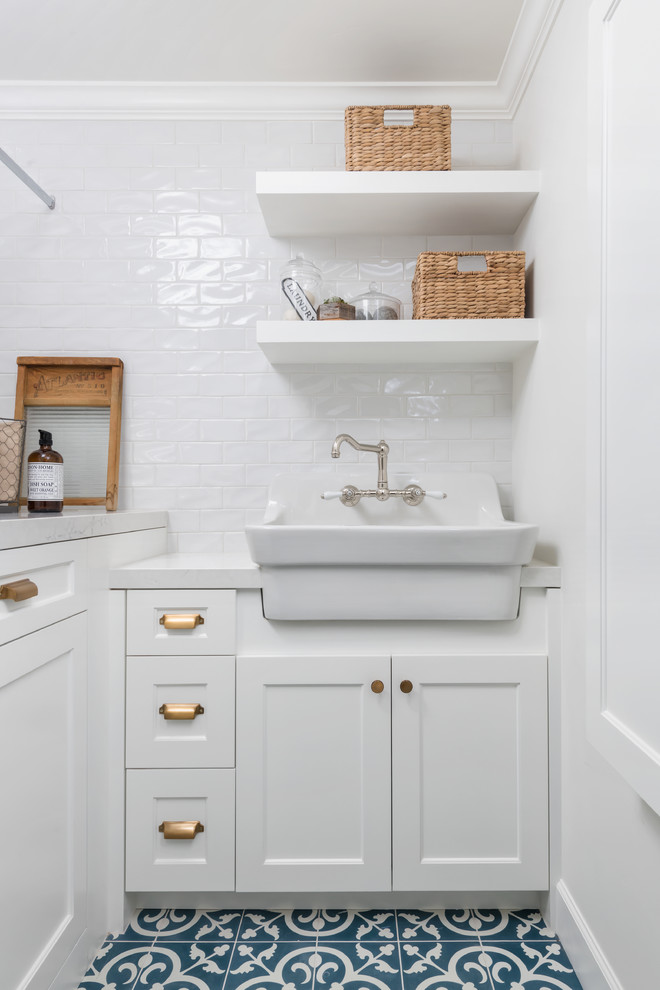 Inspiration for a small country l-shaped dedicated laundry room in San Francisco with a farmhouse sink, beaded inset cabinets, white cabinets, quartz benchtops, white walls, ceramic floors, a side-by-side washer and dryer, blue floor and white benchtop.
