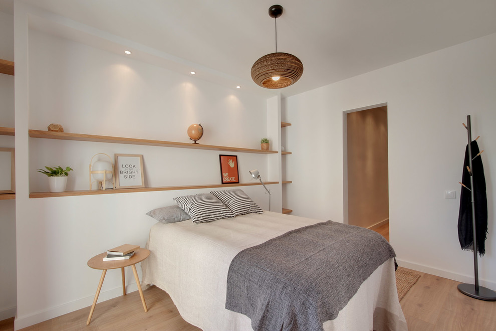 Design ideas for a mid-sized scandinavian master bedroom in Barcelona with white walls, medium hardwood floors and no fireplace.