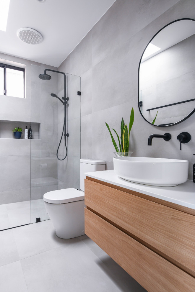 Mid-sized modern bathroom in Sydney with flat-panel cabinets, brown cabinets, gray tile, ceramic tile, ceramic floors, engineered quartz benchtops, grey floor, a hinged shower door, a niche, a single vanity, a floating vanity, a curbless shower, a two-piece toilet, a vessel sink and white benchtops.