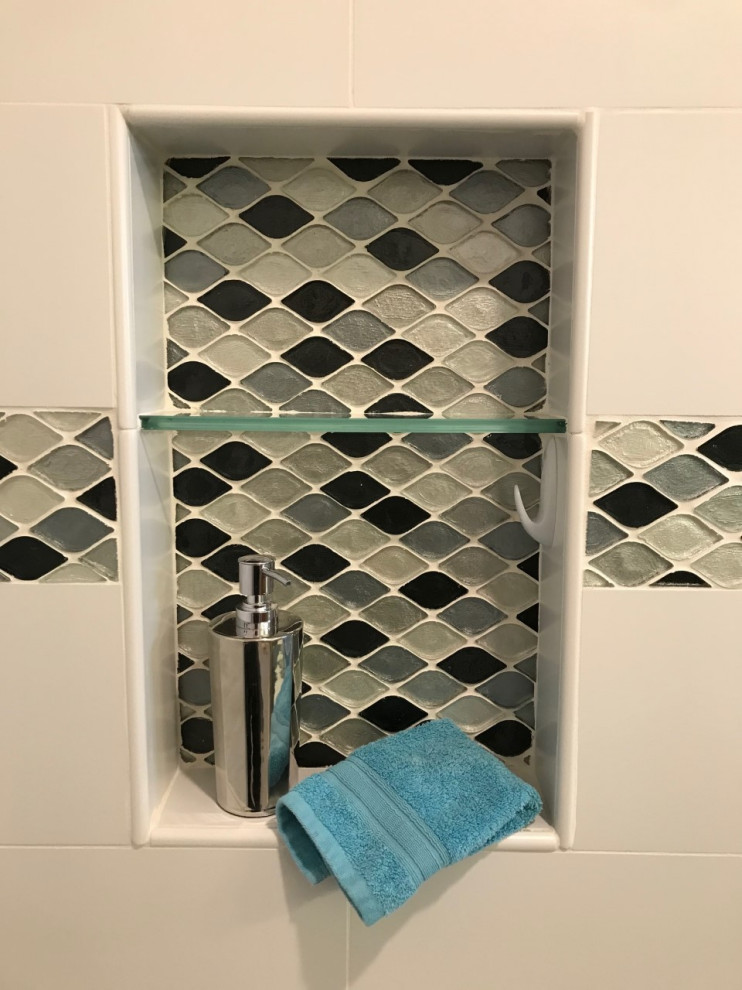 Photo of a mid-sized transitional master bathroom in Other with raised-panel cabinets, medium wood cabinets, an alcove shower, white tile, ceramic tile, blue walls, porcelain floors, an undermount sink, engineered quartz benchtops, grey floor, a sliding shower screen, grey benchtops, a niche, a double vanity and a built-in vanity.