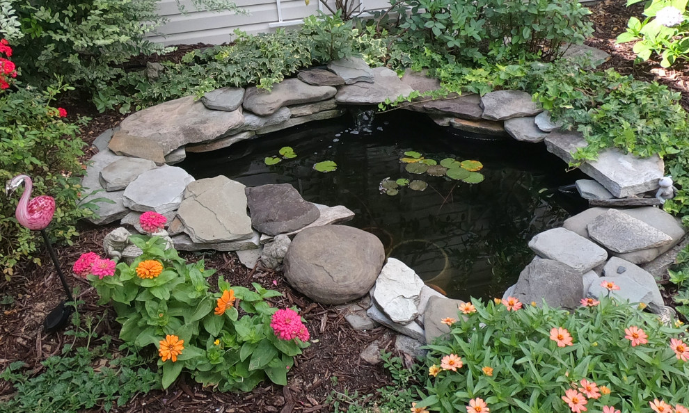 Ispirazione per un laghetto da giardino dietro casa con pavimentazioni in pietra naturale