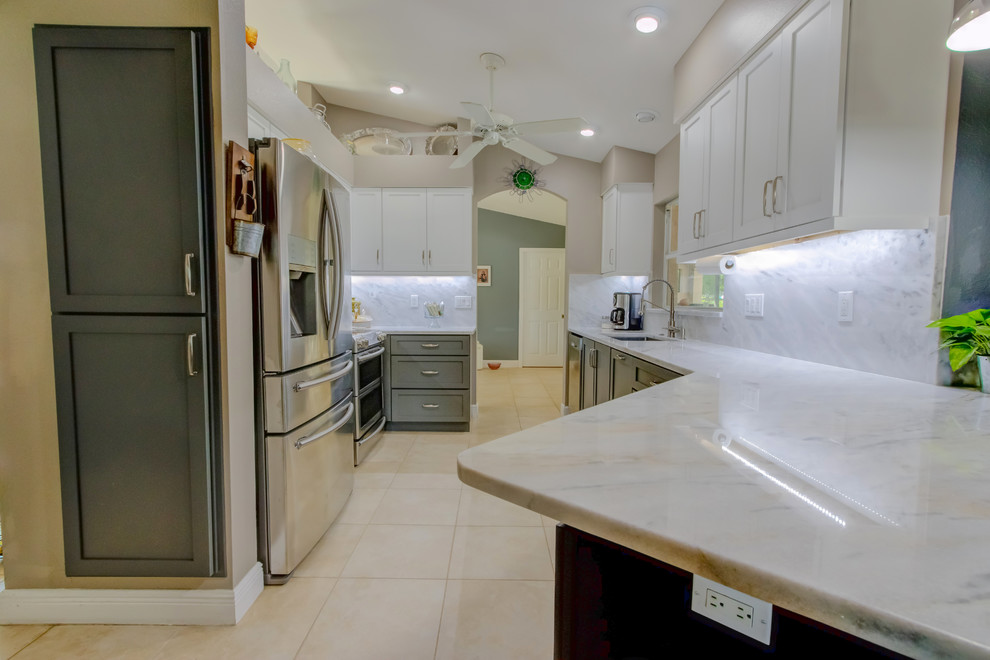 Inspiration for a mid-sized contemporary galley kitchen pantry remodel with an undermount sink, shaker cabinets, white cabinets, quartz countertops, white backsplash, stone slab backsplash, stainless steel appliances, a peninsula and white countertops