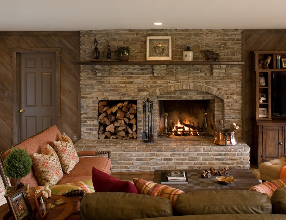 This is an example of a traditional family room in DC Metro with brown walls, a standard fireplace and a brick fireplace surround.