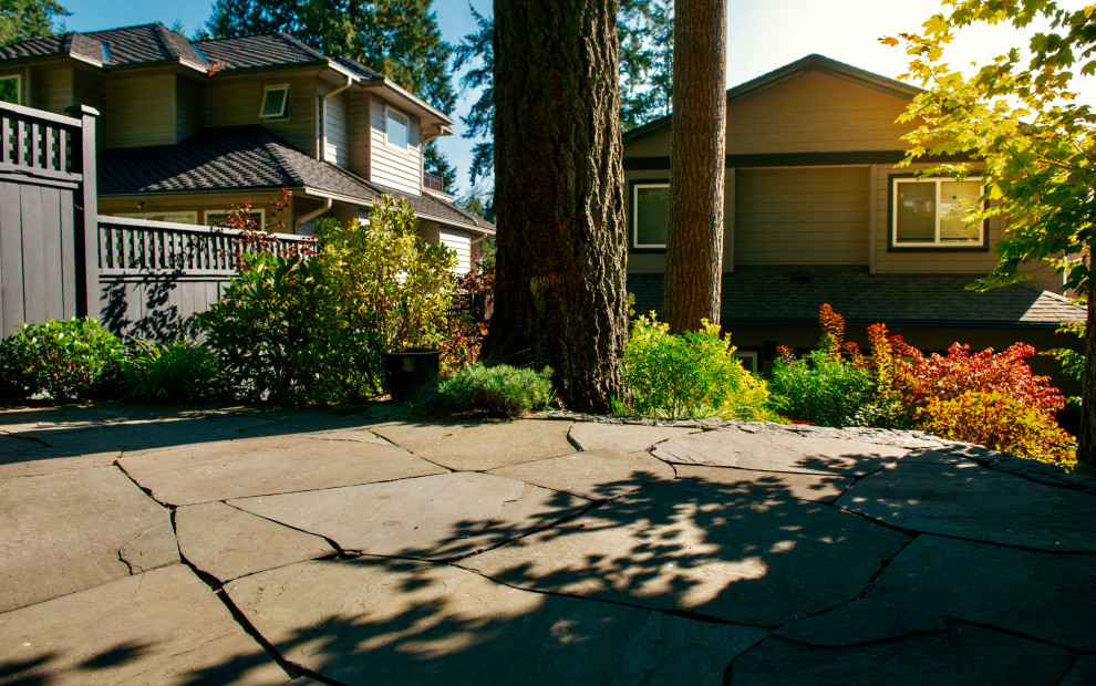 Foto di un giardino rustico esposto a mezz'ombra dietro casa con pavimentazioni in pietra naturale e recinzione in legno