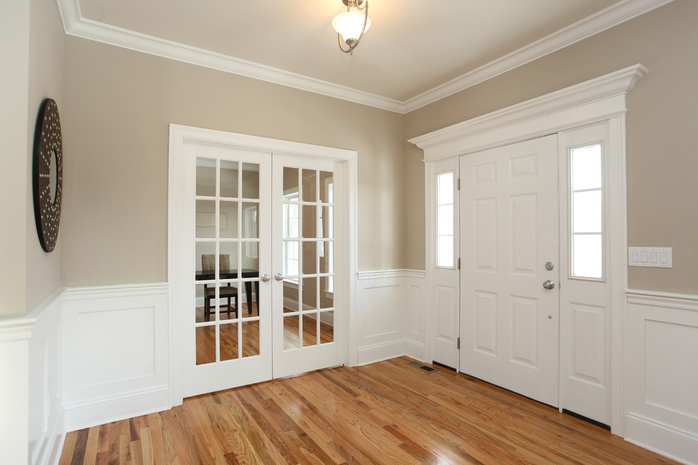 This is an example of a transitional front door in New York with beige walls, medium hardwood floors, a pivot front door and a white front door.