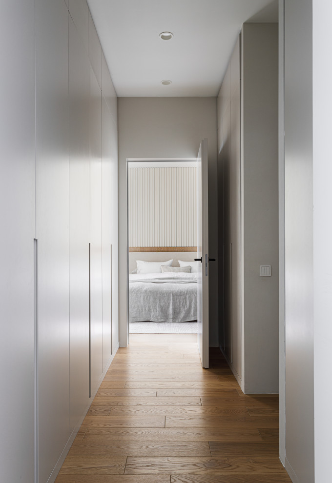 Immagine di un armadio incassato contemporaneo di medie dimensioni con ante lisce, ante beige, parquet chiaro e pavimento beige