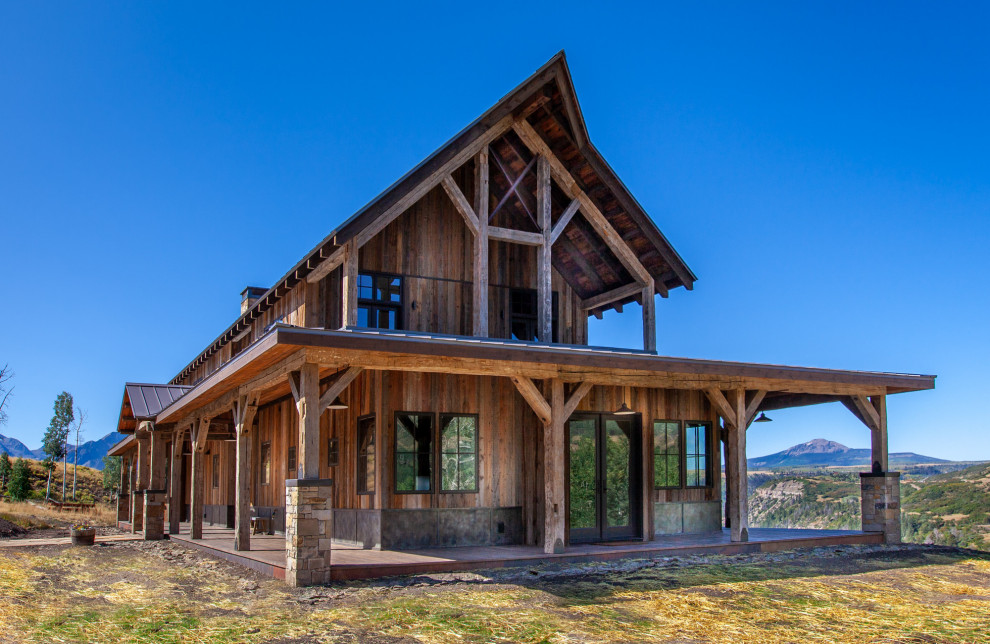 Ispirazione per la villa marrone rustica a due piani di medie dimensioni con rivestimento in legno, tetto a capanna e copertura in metallo o lamiera