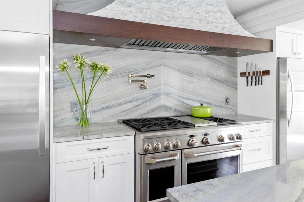 Enclosed kitchen - mid-sized transitional dark wood floor enclosed kitchen idea with a farmhouse sink, recessed-panel cabinets, white cabinets, quartzite countertops, multicolored backsplash, stone slab backsplash, stainless steel appliances, an island and multicolored countertops