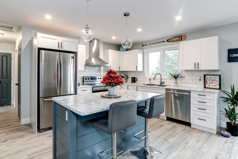 Example of a mid-sized minimalist vinyl floor and gray floor kitchen design with shaker cabinets, white cabinets, white backsplash, ceramic backsplash, stainless steel appliances and an island