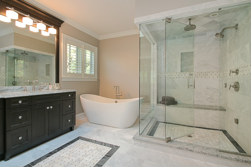 Design ideas for a large arts and crafts master bathroom in Chicago with shaker cabinets, dark wood cabinets, a freestanding tub, a corner shower, a two-piece toilet, gray tile, multi-coloured tile, stone tile, beige walls, marble floors, an undermount sink and granite benchtops.