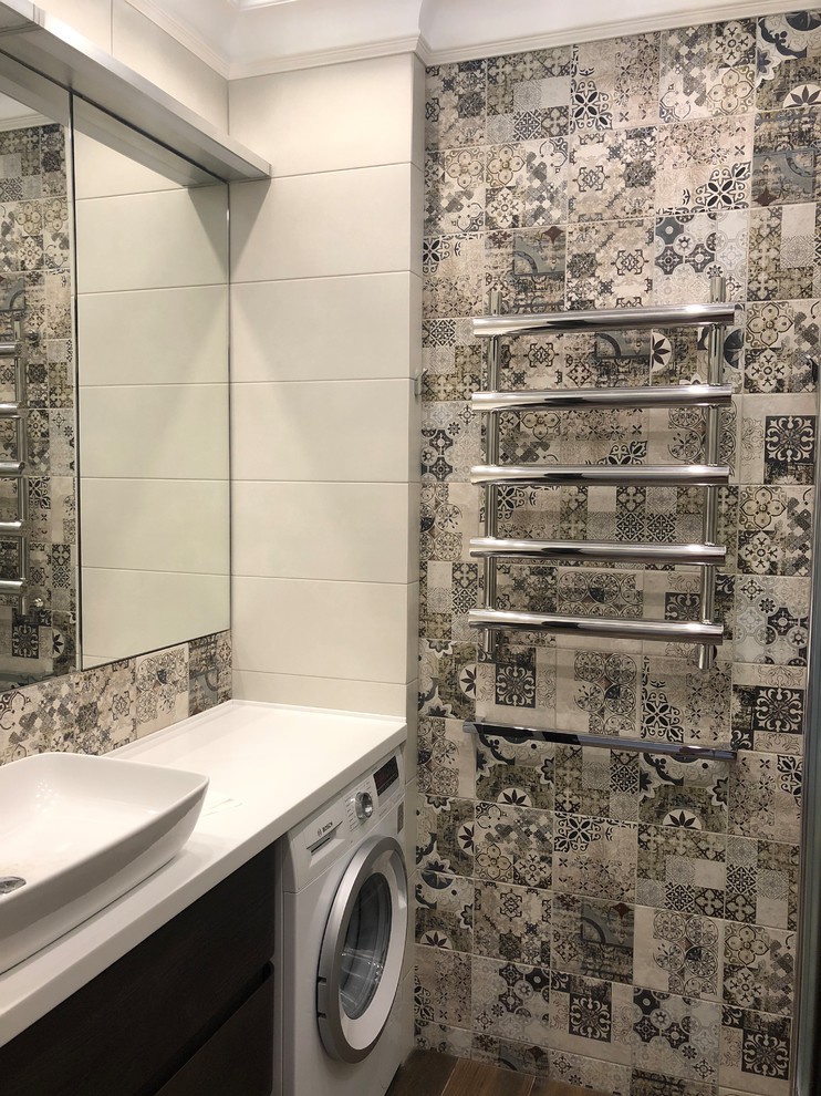 Mid-sized industrial powder room in Saint Petersburg with flat-panel cabinets, dark wood cabinets, multi-coloured tile, ceramic tile, multi-coloured walls, ceramic floors, a vessel sink, solid surface benchtops, brown floor and white benchtops.