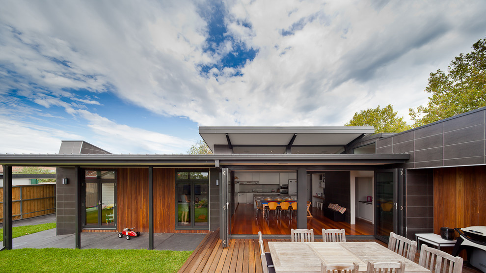 This is an example of a contemporary one-storey grey exterior in Melbourne with mixed siding and a flat roof.
