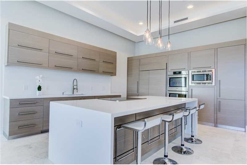 This is an example of a mid-sized contemporary l-shaped separate kitchen in Miami with a double-bowl sink, flat-panel cabinets, medium wood cabinets, quartz benchtops, white splashback, porcelain splashback, stainless steel appliances, porcelain floors and with island.