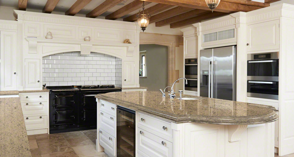 Inspiration for a mid-sized transitional galley medium tone wood floor enclosed kitchen remodel in Boston with an undermount sink, beaded inset cabinets, white cabinets, marble countertops, white backsplash, stone tile backsplash, stainless steel appliances and an island