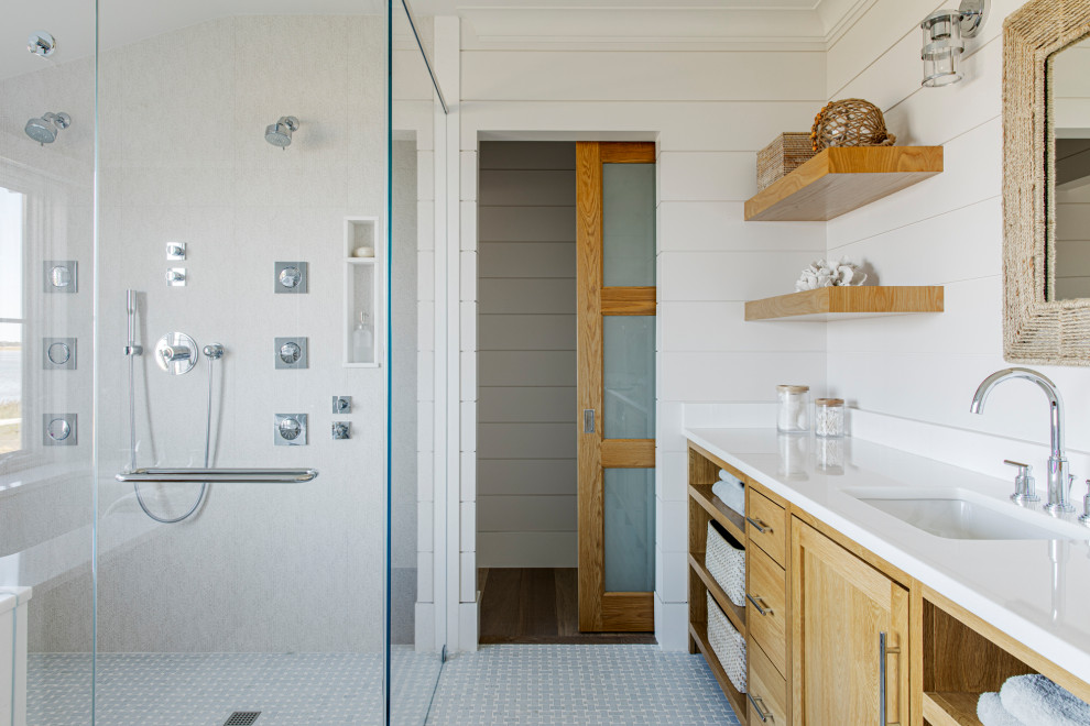 На фото: главная ванная комната среднего размера в морском стиле с фасадами с утопленной филенкой, светлыми деревянными фасадами, ванной в нише, душем в нише, белыми стенами, полом из керамической плитки, врезной раковиной, столешницей из кварцита, разноцветным полом, душем с распашными дверями, белой столешницей, тумбой под одну раковину, встроенной тумбой, потолком из вагонки и стенами из вагонки