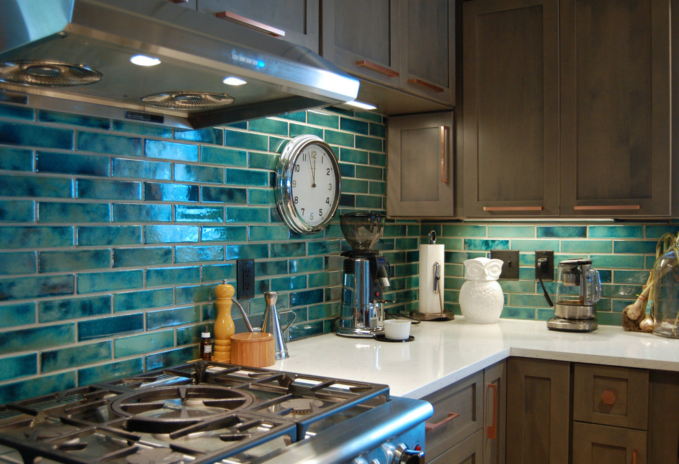 Transitional l-shaped light wood floor and multicolored floor open concept kitchen photo with a farmhouse sink, shaker cabinets, gray cabinets, quartzite countertops, blue backsplash, ceramic backsplash, stainless steel appliances and an island