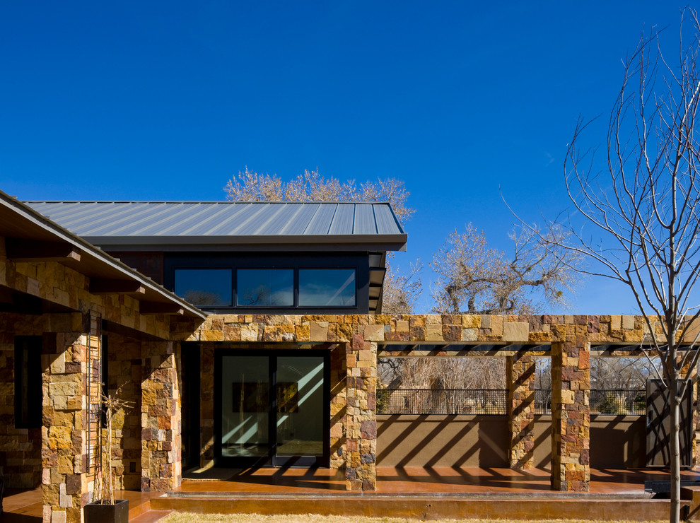 Photo of an expansive contemporary two-storey brown exterior in Albuquerque with stone veneer.