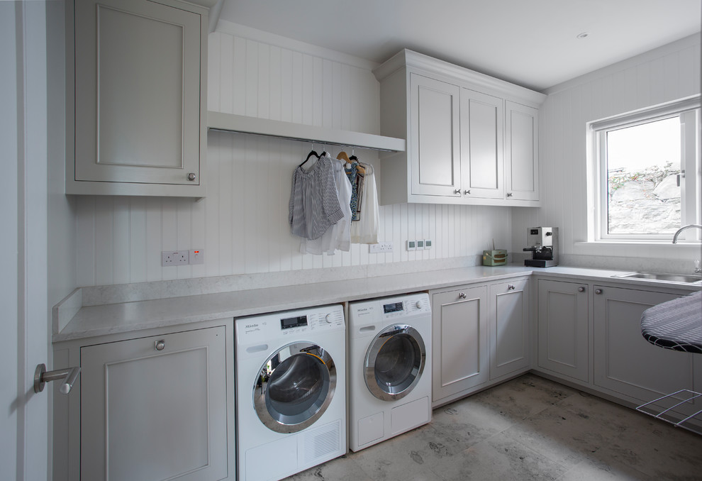 Inspiration for a large contemporary l-shaped laundry room in Other with a single-bowl sink, recessed-panel cabinets, grey cabinets, white walls and a side-by-side washer and dryer.