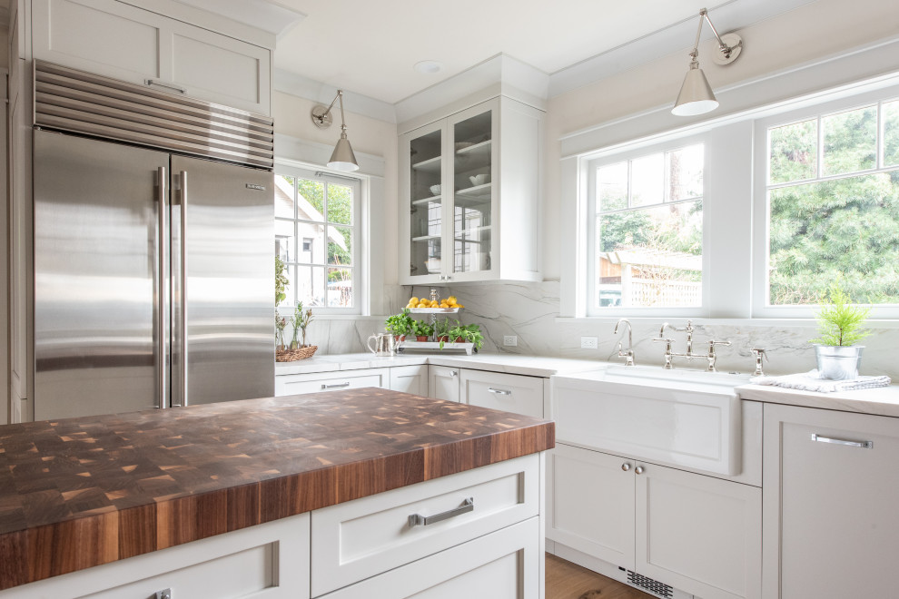 Inspiration for a mid-sized transitional u-shaped separate kitchen in Seattle with a farmhouse sink, recessed-panel cabinets, white cabinets, quartzite benchtops, white splashback, stone slab splashback, stainless steel appliances, light hardwood floors, with island, brown floor, white benchtop and coffered.