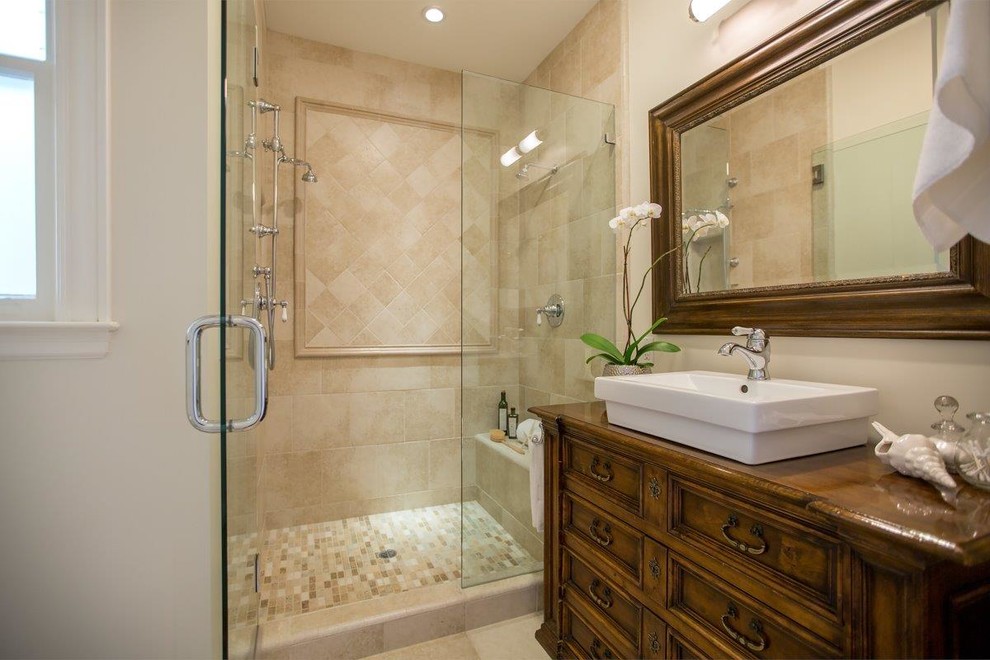Photo of a mid-sized traditional 3/4 bathroom in San Francisco with furniture-like cabinets, dark wood cabinets, a freestanding tub, an alcove shower, beige tile, ceramic tile, a vessel sink, wood benchtops, beige walls, travertine floors, beige floor, a hinged shower door and a shower seat.