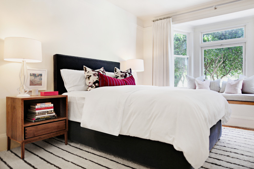 This is an example of a mid-sized transitional master bedroom in San Francisco with white walls and medium hardwood floors.
