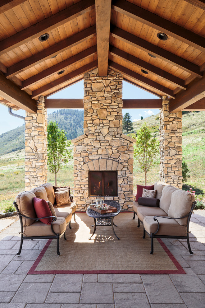 Mediterranean patio in Denver with a roof extension and with fireplace.