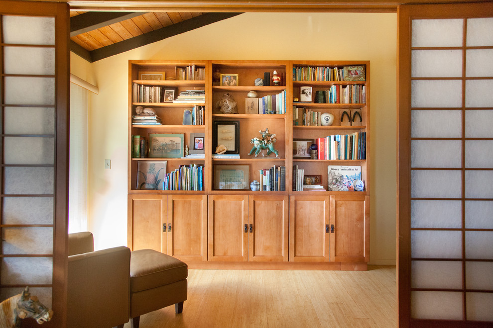 This is an example of a mid-sized asian open concept family room in Hawaii with a library and bamboo floors.