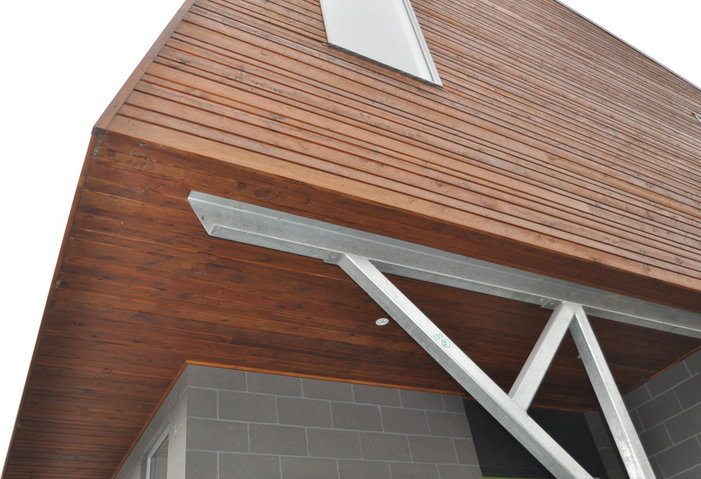 This is an example of a mid-sized contemporary two-storey multi-coloured house exterior in Melbourne with wood siding, a shed roof and a metal roof.