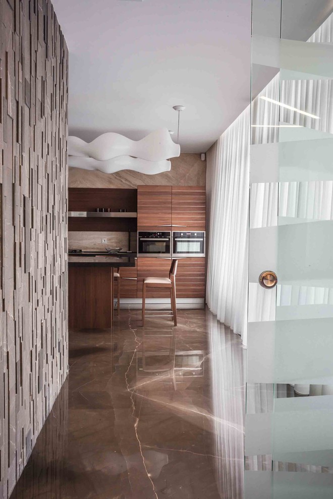 This is an example of a large contemporary l-shaped eat-in kitchen in Moscow with an undermount sink, flat-panel cabinets, medium wood cabinets, granite benchtops, beige splashback, stone slab splashback, stainless steel appliances, marble floors and with island.