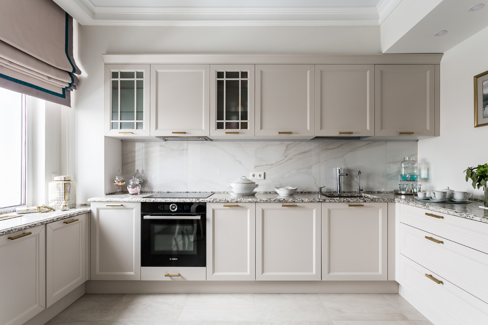 Design ideas for a mid-sized transitional u-shaped kitchen in Saint Petersburg with an undermount sink, beige cabinets, granite benchtops, white splashback, porcelain splashback, porcelain floors, no island, beige floor, recessed-panel cabinets, black appliances and beige benchtop.