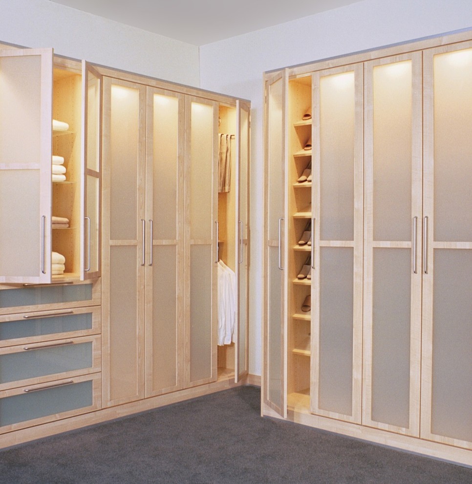 Photo of a mid-sized scandinavian gender-neutral walk-in wardrobe in Other with glass-front cabinets, light wood cabinets and carpet.