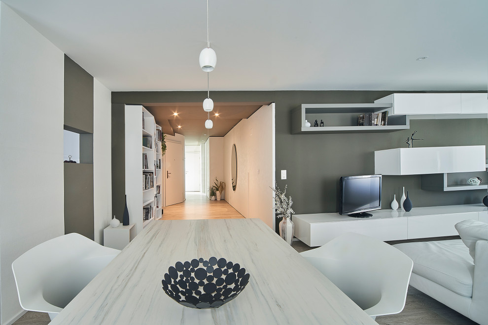 Свежая идея для дизайна: гостиная-столовая среднего размера в современном стиле с белыми стенами, светлым паркетным полом, многоуровневым потолком и панелями на стенах - отличное фото интерьера