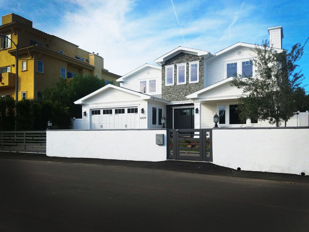 Mid-sized beach style two-storey white house exterior in Los Angeles with vinyl siding, a gable roof and a shingle roof.