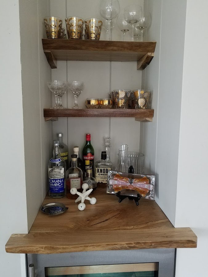 Inspiration for a small country single-wall wet bar in Chicago with no sink, glass-front cabinets, grey cabinets, wood benchtops, white splashback, timber splashback, dark hardwood floors, brown floor and brown benchtop.