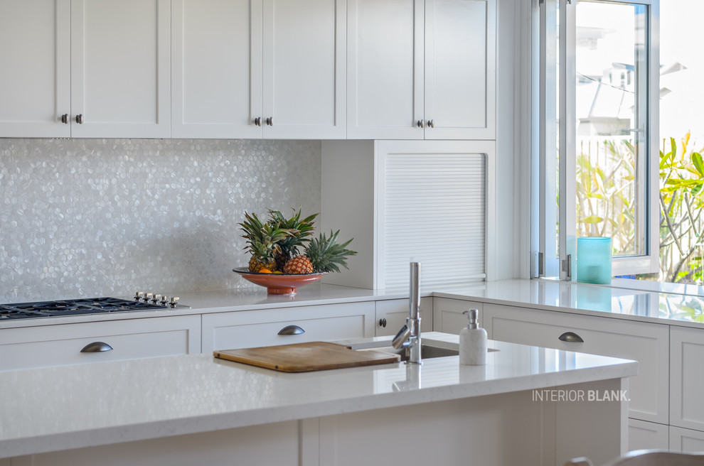 Design ideas for a large transitional l-shaped open plan kitchen in Gold Coast - Tweed with a double-bowl sink, recessed-panel cabinets, white cabinets, quartz benchtops, white splashback, mosaic tile splashback, stainless steel appliances, medium hardwood floors, with island and brown floor.