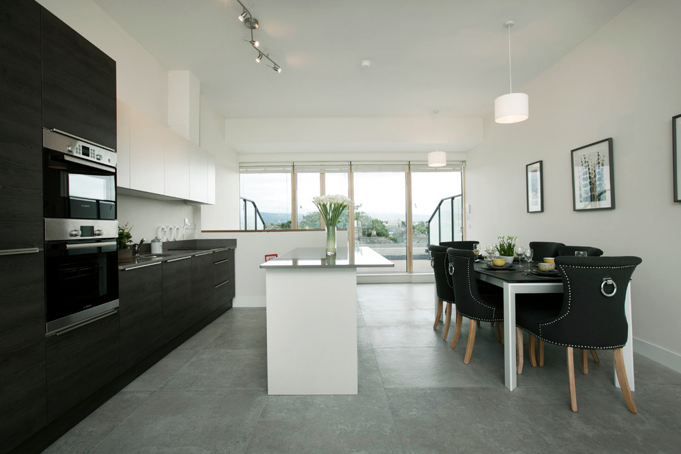 Mid-sized contemporary single-wall kitchen in Dublin with an undermount sink, flat-panel cabinets, quartz benchtops, stainless steel appliances and a peninsula.