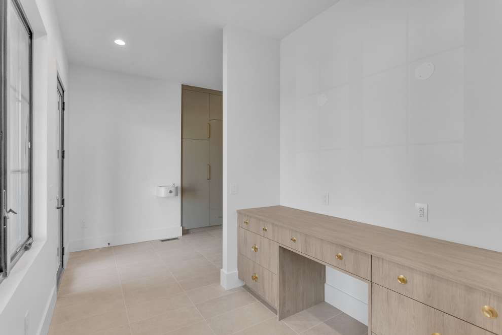Large transitional ceramic tile and beige floor mudroom photo with white walls and a glass front door