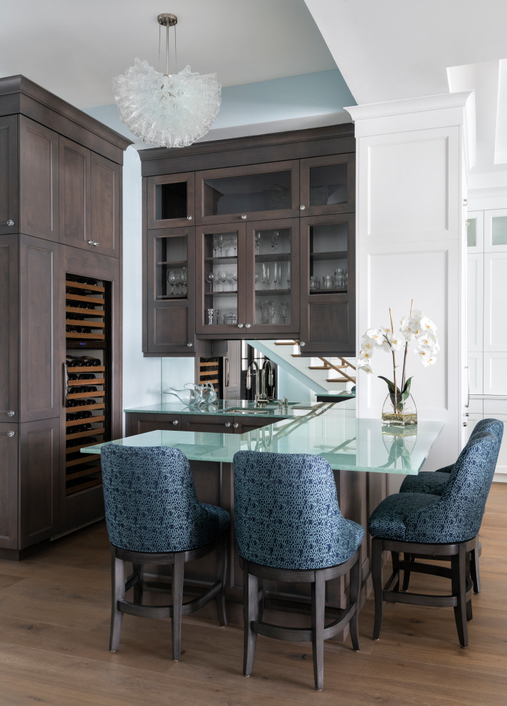 Photo of a large beach style u-shaped seated home bar in Other with an undermount sink, shaker cabinets, dark wood cabinets, recycled glass benchtops, medium hardwood floors, brown floor and turquoise benchtop.