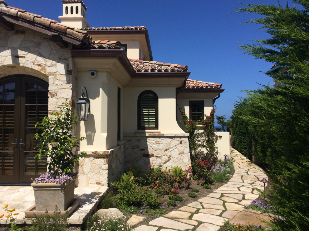 Inspiration for a mid-sized coastal beige two-story stucco house exterior remodel in San Luis Obispo with a hip roof, a tile roof and a red roof
