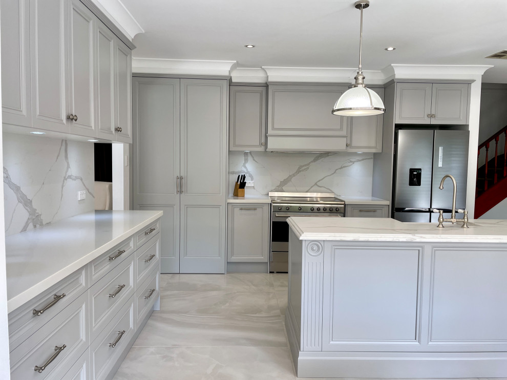 Inspiration for a large timeless l-shaped ceramic tile and gray floor eat-in kitchen remodel in Sydney with a farmhouse sink, recessed-panel cabinets, gray cabinets, quartz countertops, gray backsplash, quartz backsplash, stainless steel appliances, an island and white countertops