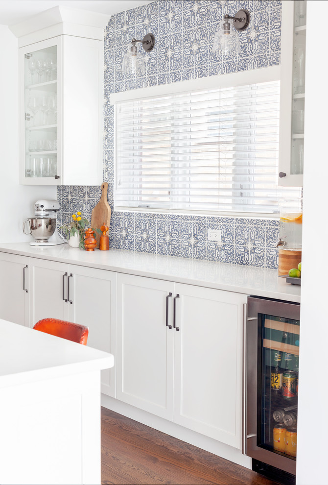 Transitional dark wood floor and brown floor kitchen photo in Chicago with shaker cabinets, white cabinets, quartzite countertops, multicolored backsplash, stone tile backsplash, stainless steel appliances, an island and white countertops