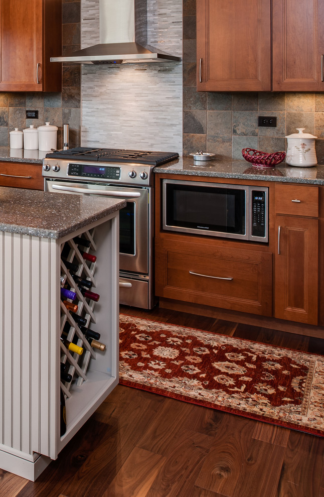 Inspiration for a mid-sized transitional l-shaped medium tone wood floor eat-in kitchen remodel with shaker cabinets, medium tone wood cabinets, quartz countertops, multicolored backsplash, stone tile backsplash, stainless steel appliances and an island