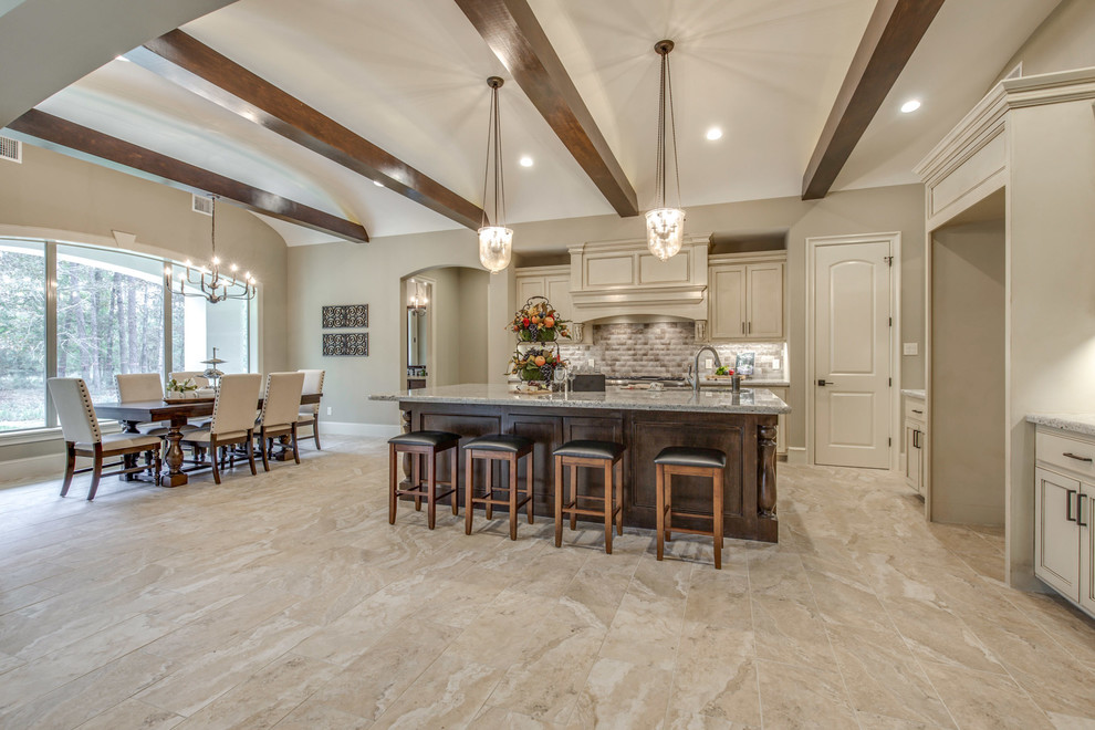 Inspiration for a large mediterranean l-shaped eat-in kitchen in Houston with recessed-panel cabinets, white cabinets, granite benchtops, beige splashback, ceramic splashback, stainless steel appliances, with island, an undermount sink, ceramic floors and beige floor.