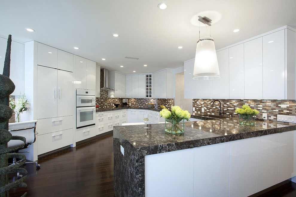 Large contemporary u-shaped separate kitchen in Miami with dark hardwood floors, white cabinets, multi-coloured splashback, a drop-in sink, flat-panel cabinets, marble benchtops, white appliances, a peninsula, brown floor and multi-coloured benchtop.